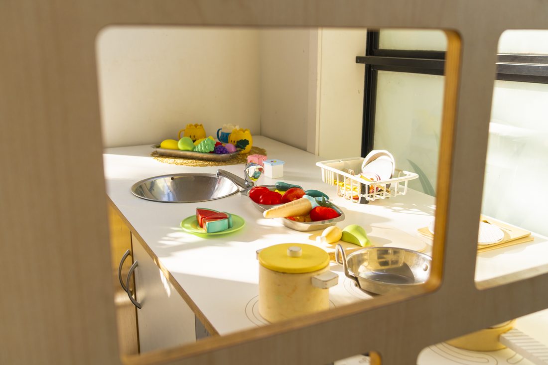 Play kitchen bench with pretend food and dishes