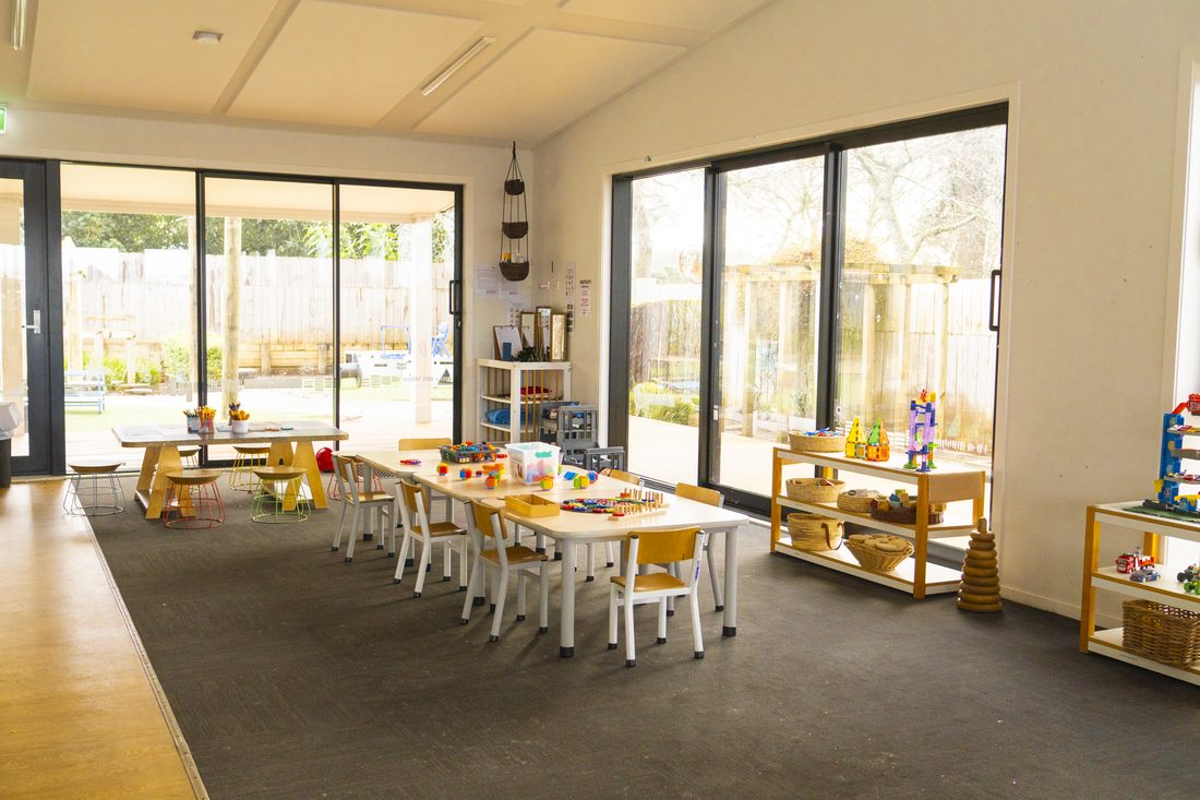 Open mat space of the Morepork room with glass doors to the deck