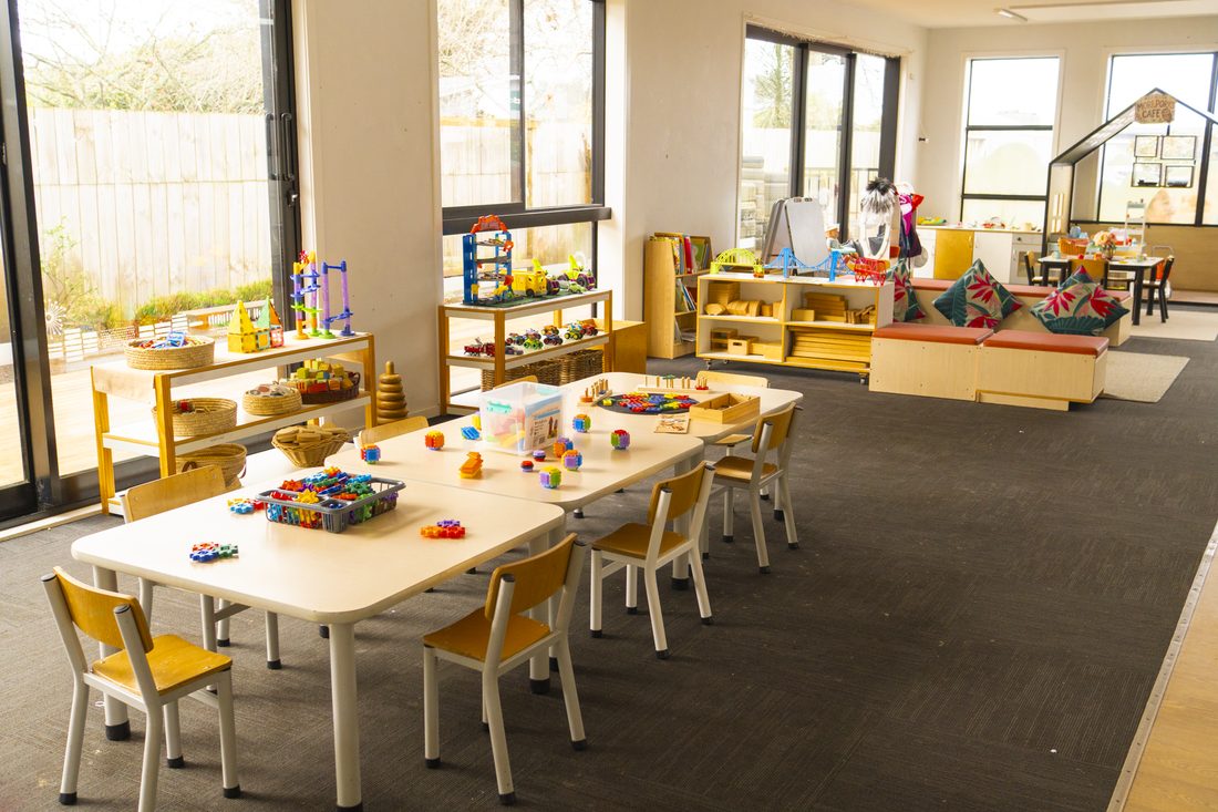 Craft supplies and drawing paper set out on the activity table