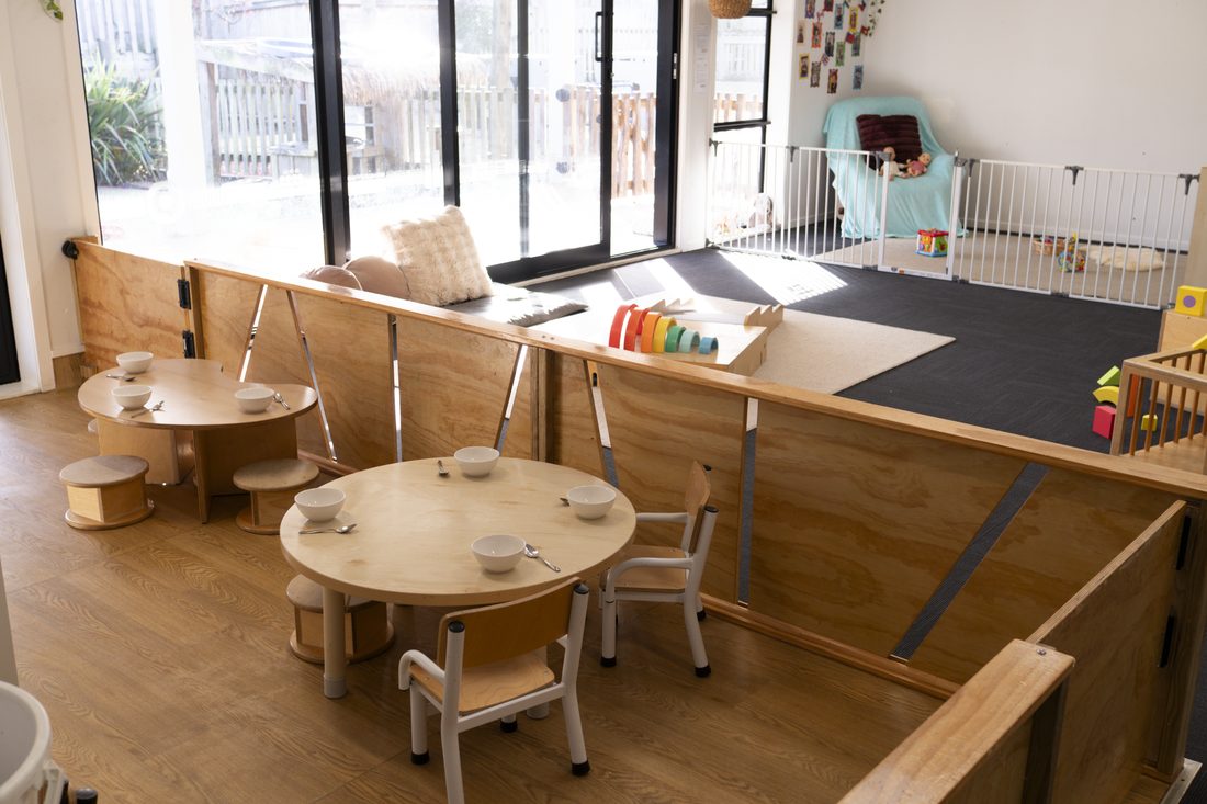 Open play area of the Nest room with wooden play furniture